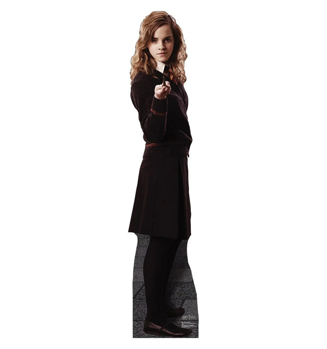 A young woman with wavy brown hair wearing a dark grey sweater, skirt, and tights, holding a wand.