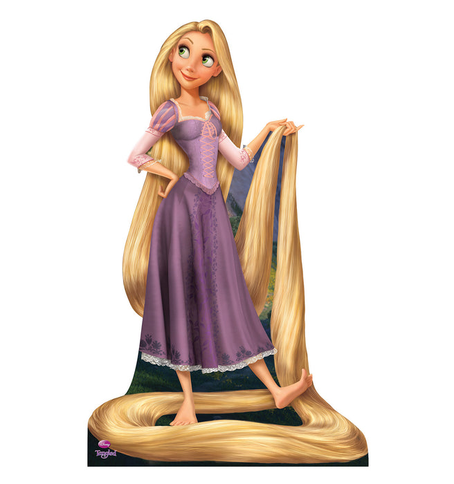 Life-size cardboard cutout of a cartoon princess with long golden hair wearing a purple dress, standing barefoot with her hair wrapped around her feet and held in one hand, smiling and gazing off to the side.