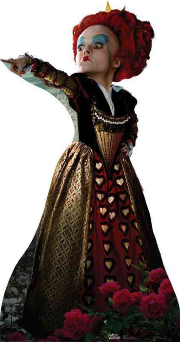 A woman with bright red hair styled high, wearing a gold, black, and red gown with heart patterns and dramatic blue eyeshadow, pointing with an outstretched arm.