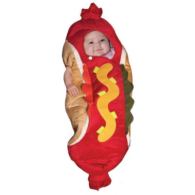 An infant dressed in a hotdog costume, featuring a soft bun-shaped suit with a hotdog body and a yellow mustard squiggle on the front. The baby is smiling, wearing a humorous and cozy outfit perfect for Halloween or playful events.