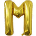 Gold foil balloon shaped like the letter M.