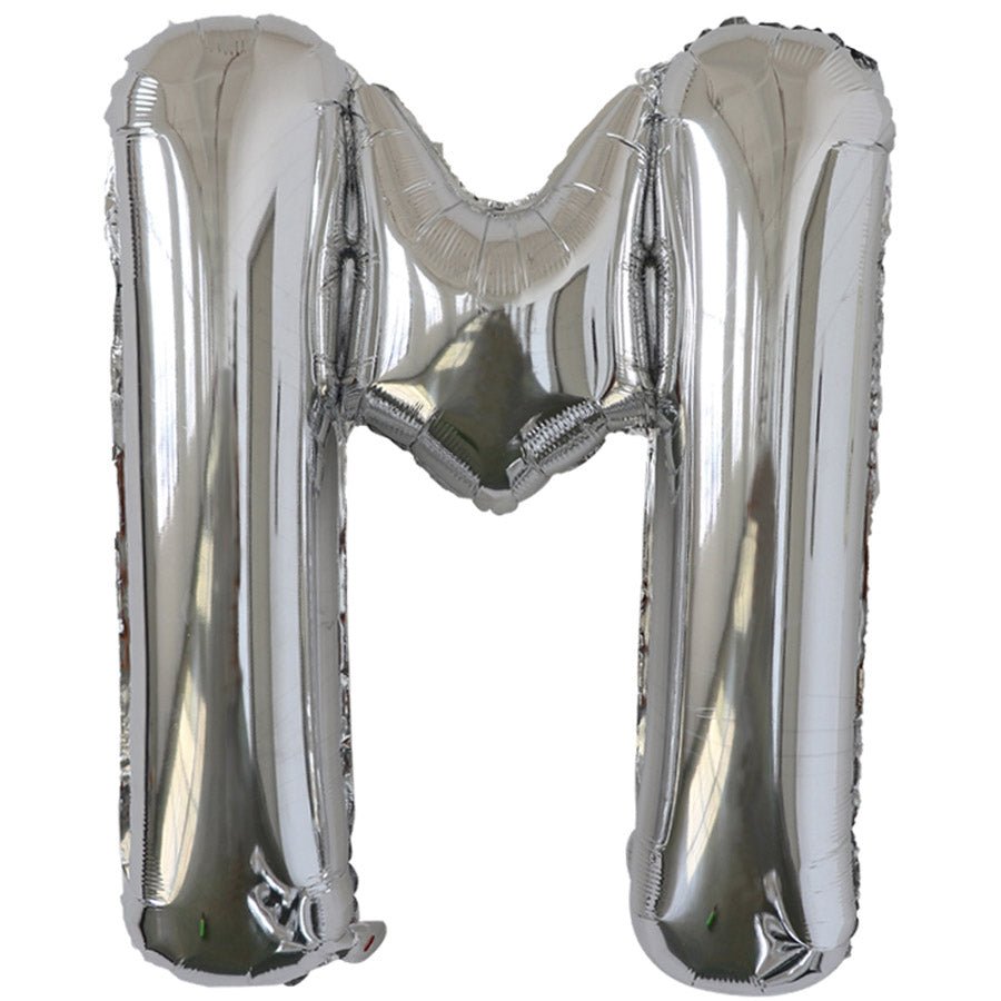Silver foil balloon shaped like the letter M.
