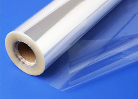 A clear roll of cellophane wrapping with a glossy, transparent finish. The roll is wound around a cardboard core, and a sheet of the cellophane is partially unrolled to show its smooth, flexible texture. Commonly used for gift wrapping, crafts, and packaging.