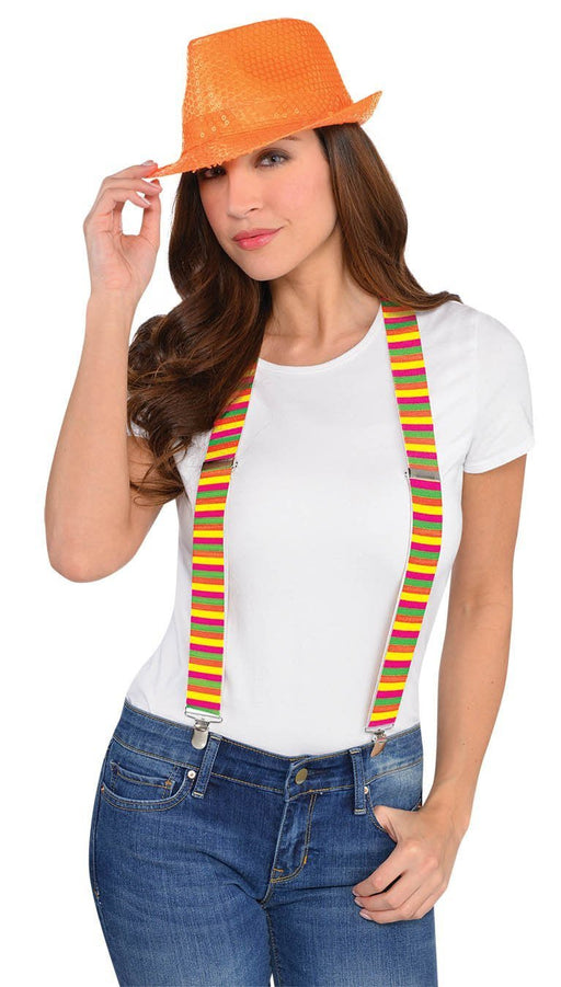 Smiling woman wearing a bright orange fedora hat, a plain white t-shirt, and colorful striped suspenders in pink, yellow, and green, paired with blue jeans.