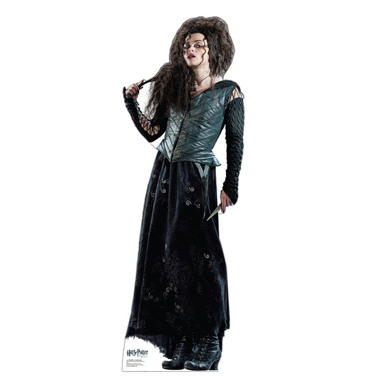A life-size cutout of a woman with long, wild dark hair wearing a dark green corset-style top and long black skirt, holding a wand in her right hand.