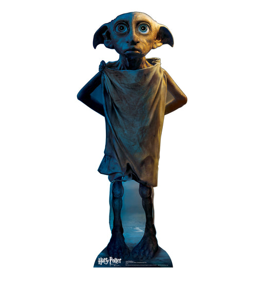 Life-size cardboard cutout of a wide-eyed house-elf character with large ears, wearing a worn-out cloth draped over his body, standing with hands behind his back. The base features the Harry Potter logo.