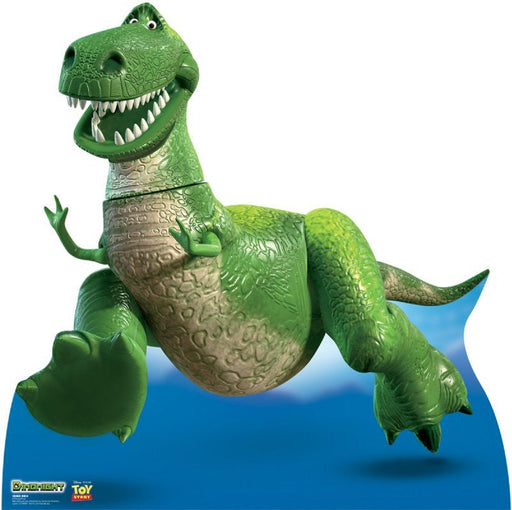 Life-size cardboard cutout of a cheerful green cartoon dinosaur with a big toothy grin and textured scales, mid-run with one foot lifted. The background shows a blue sky with clouds. Logos for 'Disney·Pixar' and 'Toy Story' are displayed in the corner.