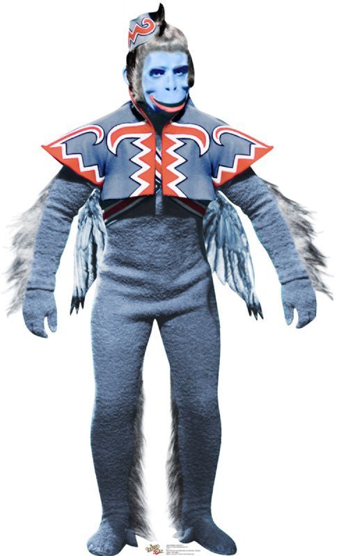 Life-size cardboard cutout of a blue-faced winged monkey character wearing a textured blue bodysuit, feathered wings, and a colorful red, blue, and white zigzag-patterned vest with a matching hat. The character has an expressive grin and theatrical appearance.