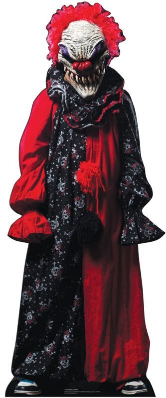 Life-size cardboard cutout of a creepy clown dressed in a black and red costume with skull patterns on one side and solid red on the other. The clown has bright red, frizzy hair and a grotesque white face with deep wrinkles, sharp teeth, and dark, sunken eyes. It wears oversized sleeves and blue sneakers, adding to its eerie appearance.