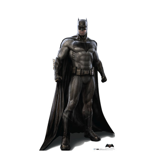 Cut-out of Batman, the comic book superhero, standing in a strong stance with fists clenched. He is wearing a dark gray armored suit with the bat emblem on his chest, a black cape draped over his shoulders, black gloves, boots, and cowl with pointed ears.