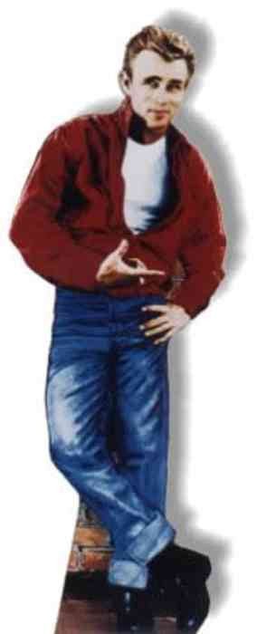 Cardboard cutout of a man with short, wavy blonde hair wearing a bright red jacket over a white t-shirt, paired with medium-wash blue jeans and black shoes. He stands in a relaxed pose with one leg crossed over the other and leans slightly to the side, gesturing casually with one hand while the other rests on his hip.