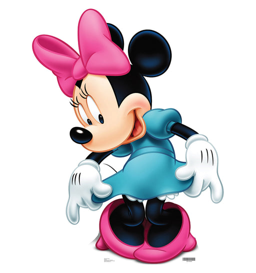 Cardboard cutout of Minnie Mouse wearing a teal blue dress with matching shoes and a large pink bow, posed with her head tilted and hands holding the sides of her skirt in a curtsy gesture.
