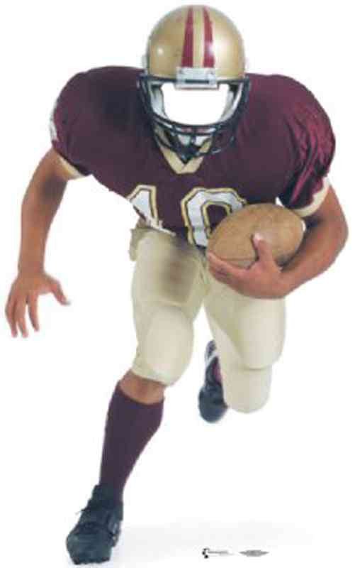 A cut out football player wearing a maroon jersey, gold helmet, and beige pants, running forward holding a football.