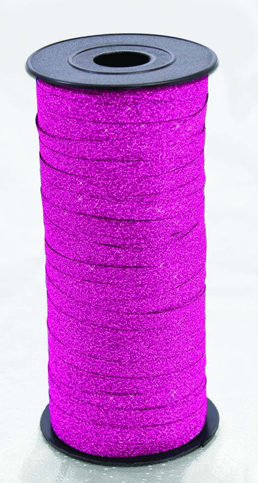 Spool of bright pink glitter ribbon wound around a black plastic reel.