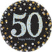 Black round plate with a large light blue glittery number '50' in the center, surrounded by gold, silver, and white confetti dots, with the words 'happy birthday' in lowercase script below the number.