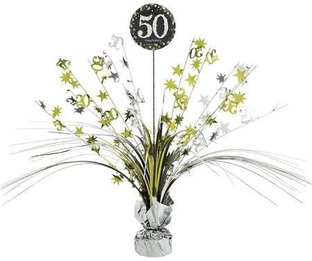 Table centerpiece decoration with metallic silver and gold foil sprays, star accents, and number cutouts, featuring a black circular topper with '50' in white glitter text.