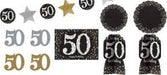 Black, gold, and silver 50th birthday decoration kit with assorted paper cutouts, banners, and table centerpieces featuring the number 50 and 'happy birthday' text in a glittery design.