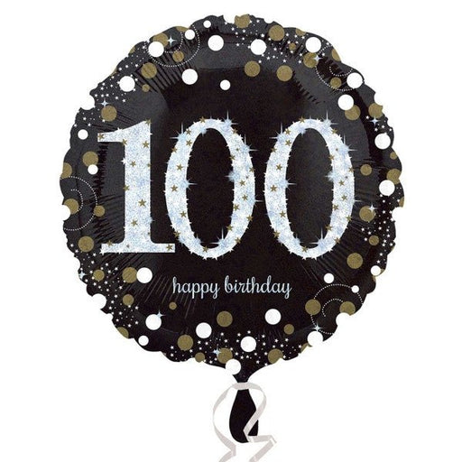 Round black foil balloon with large silver glitter-effect number '100' in the center, surrounded by gold and silver confetti dots, and the words 'happy birthday' in small white script below.