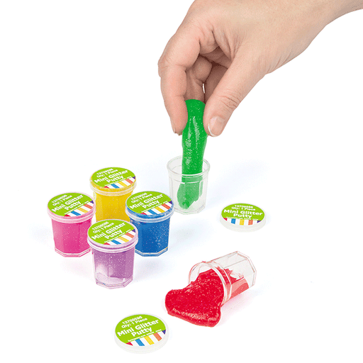 Set of colorful mini glitter putty containers with lids, shown in various shades including pink, yellow, blue, green, and red, with one hand stretching out green putty.
