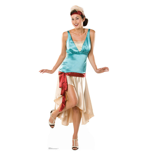 Cardboard cutout of a smiling woman in a 1920s flapper-style costume, featuring a teal satin sleeveless top, cream high-low skirt, red sash, beige heels, and a decorative headband with feather detail.