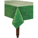 Green rectangular plastic table cover designed to resemble a grass or turf field. It drapes over the edges of a wooden table, making it suitable for sports-themed parties or outdoor events.