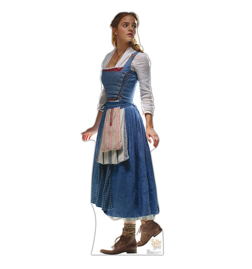 A life-size cardboard cutout of Belle from Disney’s Beauty and the Beast, wearing her classic blue dress with a white blouse underneath, an apron tied around her waist, and brown lace-up boots. She is posed looking slightly to the side with one arm extended behind her.