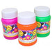 Three bottles of bubble solution in assorted colors: bright pink, orange, and green. Each bottle has a white cap and a colorful label featuring smiley faces, peace signs, yin-yang symbols, and flowers in vibrant colors, creating a cheerful and playful design.