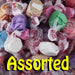 A colorful assortment of individually wrapped gourmet taffy candies in various pastel shades, labeled 'Assorted' in bold yellow text.