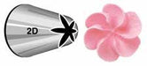 Metal piping tip labeled 2D with a large, curved open star-shaped opening, shown next to a pale pink icing flower with six softly curved petals, demonstrating the tip’s use for creating floral decorations.