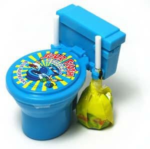 Blue plastic toilet-shaped candy container labeled 'Sour Flush' with a colorful sticker showing a cartoon blue skunk and yellow sunburst background – two white and yellow candy plunger is attached to the side – a playful dipping candy novelty treat ideal for kids’ parties, gag gifts, and sour candy lovers.