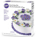 14 oz box of Wilton Royal Icing Mix, featuring an image of a white cake decorated with purple and white royal icing flowers. The packaging highlights that the mix dries hard, is ideal for flowers, and only requires water to prepare.