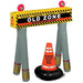 Over the Hill inflatable barricade with humorous "Old Zone - Senior Moment Alert" caution sign and an inflatable orange cone labeled "Danger Sagging Body Parts." The barricade is gray with yellow and black caution stripes and pink humorous accents on top.