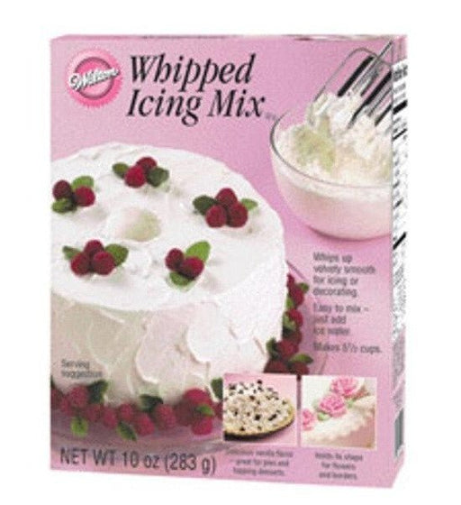 Box of Wilton Whipped Icing Mix in pink packaging, featuring a white frosted cake topped with red berries and mint leaves, a mixing bowl with beaters, and small images of decorating ideas.