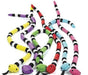 Five plush toy snakes with alternating black and white bands and colorful bodies: yellow, purple, green, red, and blue, each with a matching head color and black tongue.