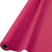 Roll of bright pink plastic table cover with cardboard core, unrolled partially over a white background.