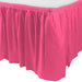 Bright pink pleated table skirt attached around the edge of a rectangular white table.