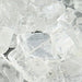 Close-up view of clear rock candy crystals showing sharp, angular sugar facets with a translucent, glass-like appearance.