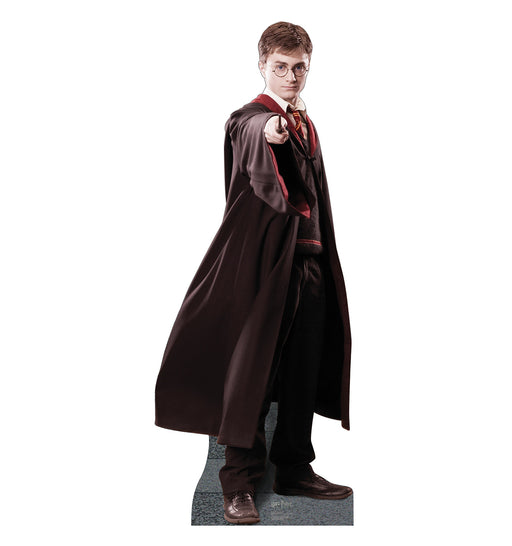 Life-size cardboard cutout of Harry Potter in a black robe, standing with one arm extended forward and holding a wand, posed as if casting a spell.