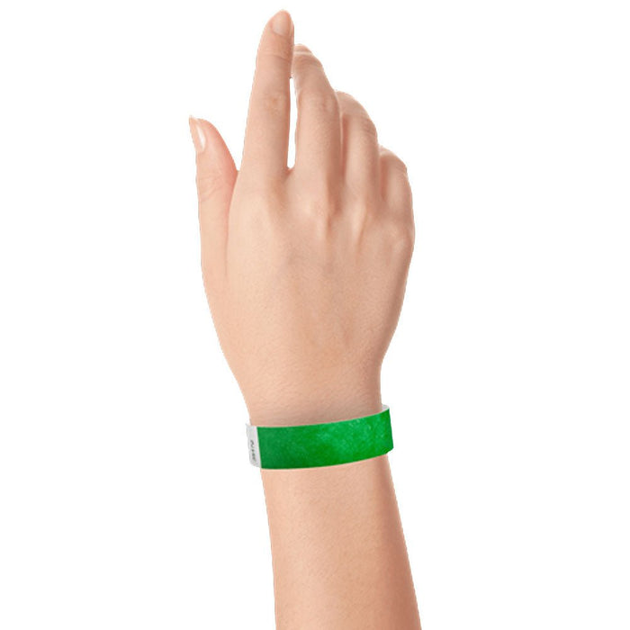 Green Tyvek wristband worn on a person's wrist with a white adhesive section visible.