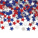 Scattered metallic star-shaped confetti in red, white, and blue colors, ideal for patriotic celebrations such as the Fourth of July, Memorial Day, or other festive events.