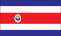 Rectangular flag with five horizontal stripes: blue on the top and bottom, white beneath the blue stripes, and a central red stripe. An emblem featuring a detailed shield is placed on the left side of the red stripe.