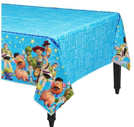 Toy Story-themed rectangular tablecloth with a bright blue top and patterned sides. The sides feature characters including Woody, Buzz Lightyear, Jessie, Rex, Hamm, Mr. Potato Head, Forky, and the Aliens, set against a blue background with stars and character names.