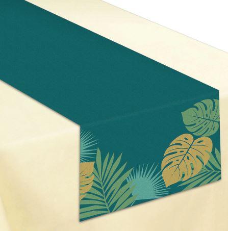 Dark teal table runner with tropical leaf designs in green and gold at the ends, displayed on a cream-colored tablecloth.