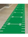 Green football field-themed floor runner with white yard lines and numbers, laid out on a hallway floor for party or sports-themed decoration.