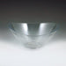 Clear plastic bowl with a smooth, glossy surface and an irregular, wavy rim shape. The bowl has a wide, open top and a narrow round base, forming an organic, flowing silhouette. It is transparent and untextured.
