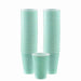 Stacks of light green plastic cups arranged in two tall columns with one cup placed in front, each with a slightly flared rim and ribbed sides.
