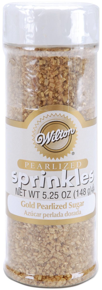 Wilton brand container of gold pearlized sugar sprinkles with a white lid and clear body revealing the golden sugar crystals. Labeled in English and Spanish with a net weight of 5.25 oz (148 g).