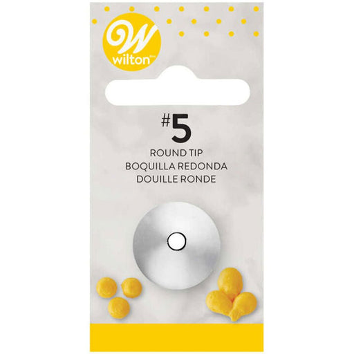 Wilton #5 round piping tip in retail packaging, featuring a small metal tip with a circular opening. The packaging includes the Wilton logo, product name in English, Spanish, and French, and images of yellow icing dots and balloon-like shapes at the bottom.