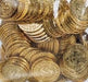 Pile of shiny gold plastic coins with embossed dollar signs and decorative patterns, viewed through a clear plastic bag.