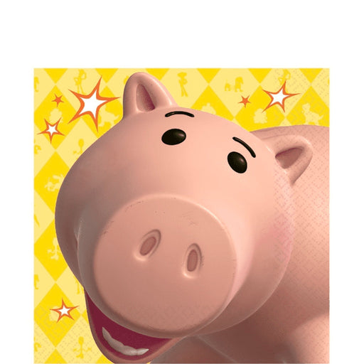 Toy Story-themed party napkin featuring Hamm the piggy bank smiling against a yellow diamond-patterned background with red and white starburst accents.